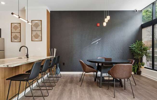 A modern dining room with a black table and chairs.