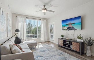 A living room with a large flat screen TV mounted on the wall.