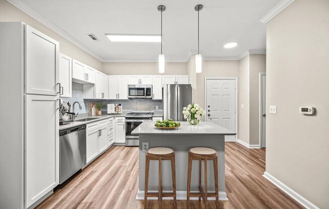 Kitchen with a central island, stainless steel appliances, and bright cabinetry, creating a functional space for cooking, dining, and everyday connection.