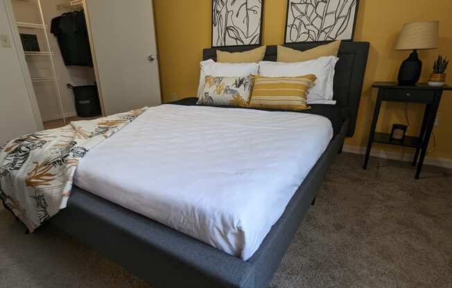 a bedroom with a bed and two paintings on the wall