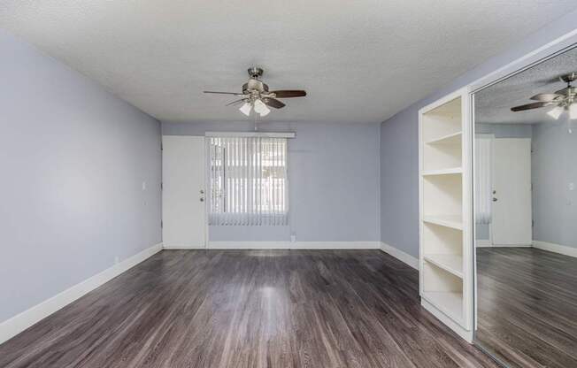 A room with a ceiling fan and a sliding door.