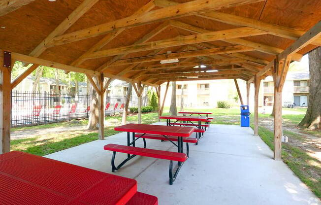 a covered picnic area with benches and tables