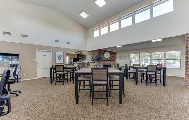 A large room with tables and chairs and a brick fireplace.