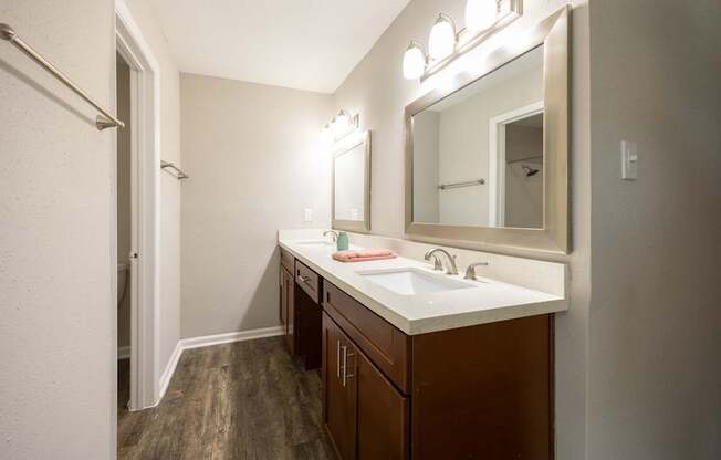 A bathroom with a white sink and brown cabinets.