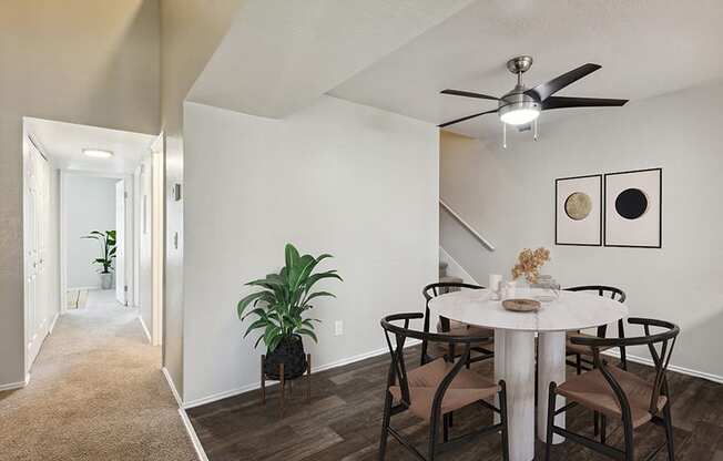 Model Dining Room with Wood-Style Flooring & View of Hallway at Broadmoor Village Apartments in Salt Lake City, UT.