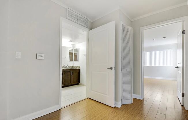 a bedroom with an open door to a bathroom and a closet