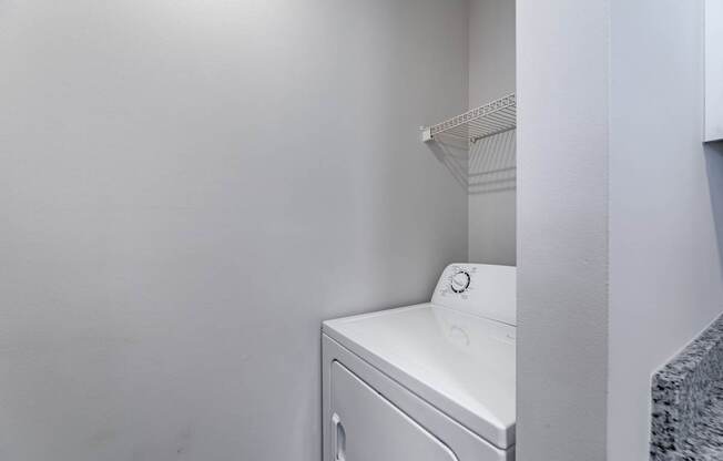 A white washing machine in a small laundry room.