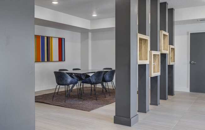 Meeting table with chairs in room behind gray beams