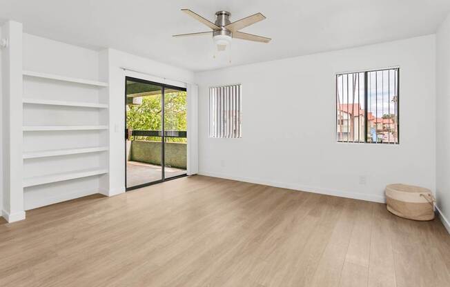 A room with a sliding glass door leading to a balcony.