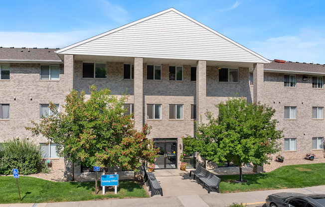 a brick apartment building with trees in front of it