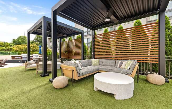 A modern outdoor seating area with a wooden bench and a white cushion.