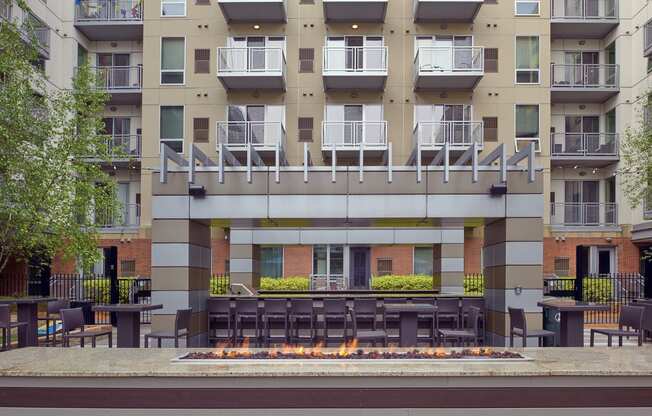 an outdoor patio with tables and chairs in front of an apartment building