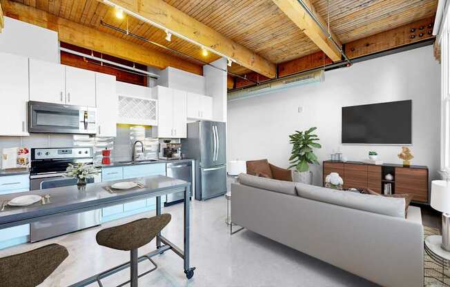 A modern kitchen with a breakfast bar and a living room area with a couch and a TV.