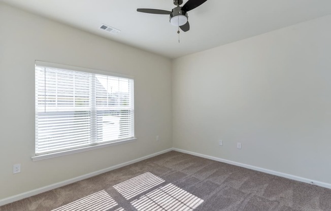 Ashland Farms Bedroom with Carpet Floors, Ceiling Fan, and Large Window