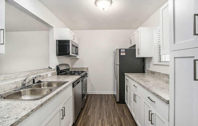 A kitchen with white cabinets and stainless steel appliances at Foxwood and The Hermitage, Portage, MI, 49024