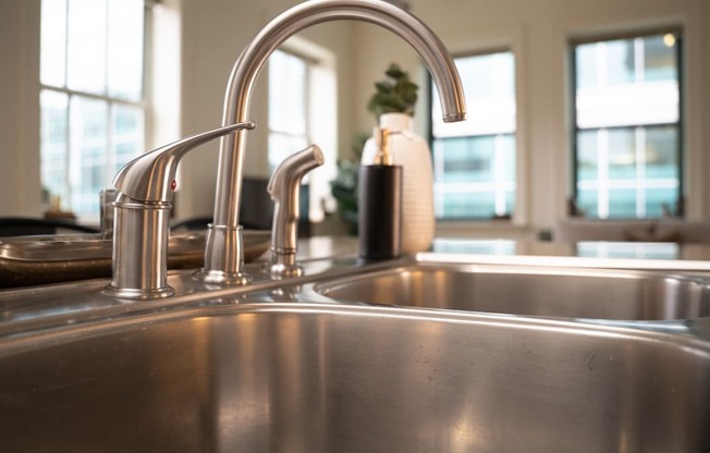 a stainless steel kitchen sink with two faucets