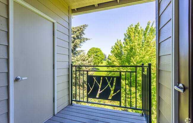 A balcony with a white door and a black railing at Wilsonville Summit Apartments, Oregon