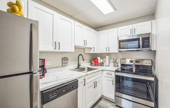 A kitchen with white cabinets and stainless steel appliances.