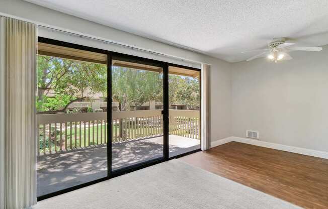 an empty living room with sliding glass doors to a balcony at Summerwood Apartments, California