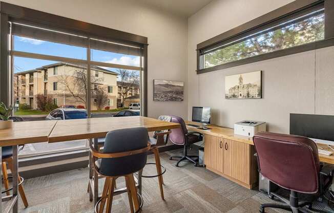 A room with a desk, chairs, and a computer.