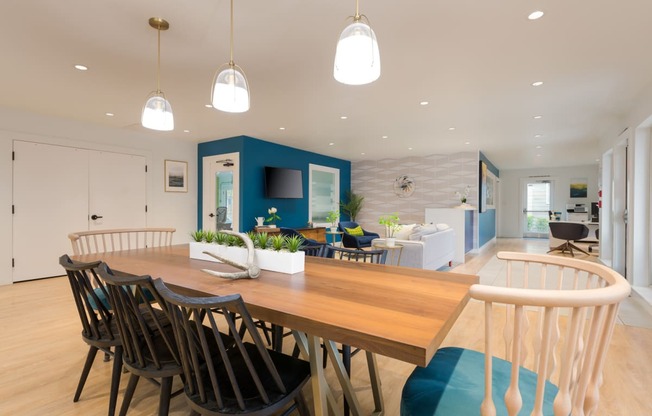 a dining area with a wooden table and chairs and a blue accent wall