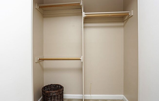 a walk in closet with empty shelves and a basket