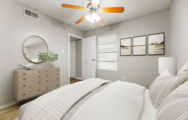 a bedroom with a bed and a ceiling fan