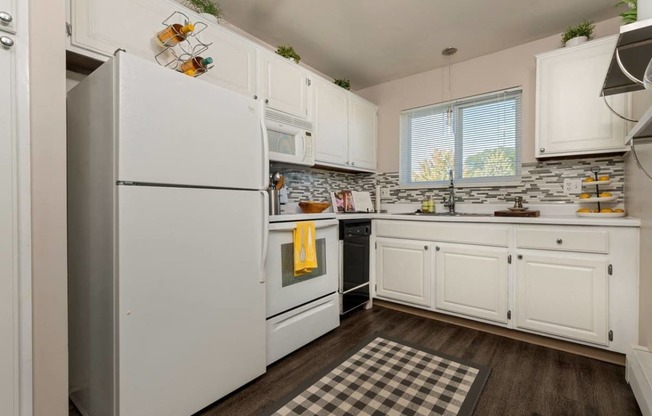 a kitchen with white cabinets and a refrigerator at Village Club of Royal Oak, Royal Oak Michigan