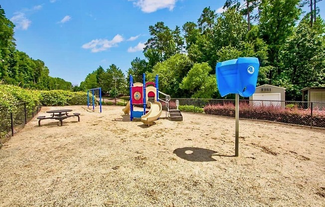 a playground with a playground equipment and picnic table in a park