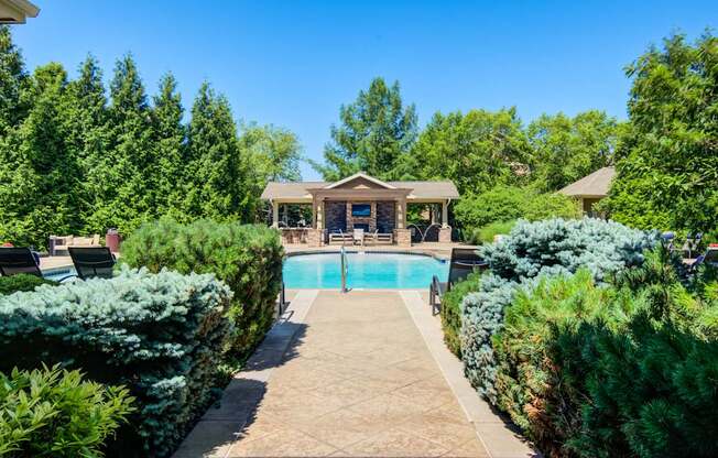 A backyard with a pool and a small house.