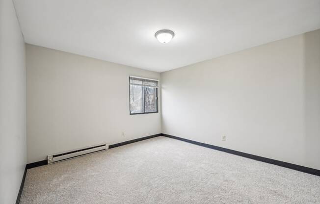 an empty room with white walls and a window