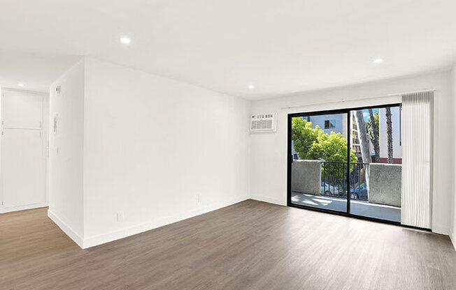 A room with a wooden floor and a sliding glass door.