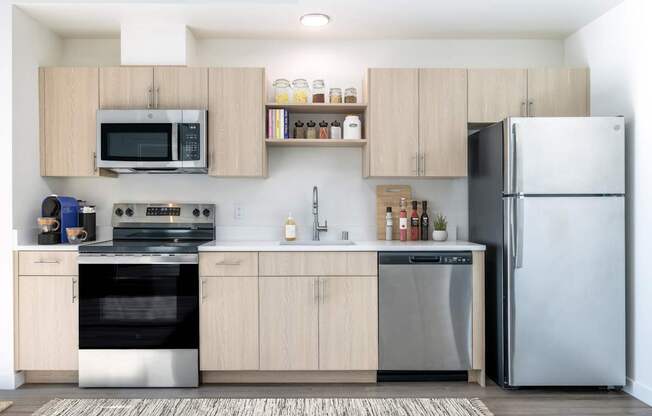 A modern kitchen with a refrigerator, oven, and microwave.