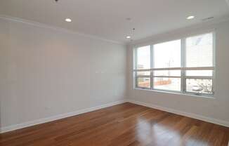 a living room with wood floors and a large window