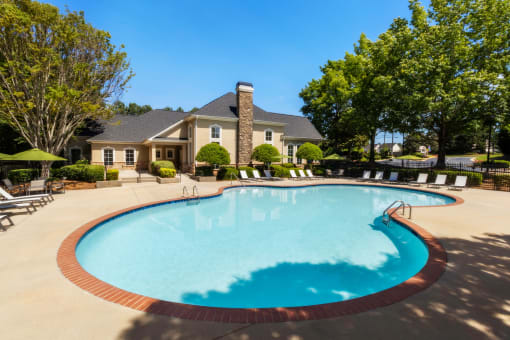 a swimming pool with a house in the background