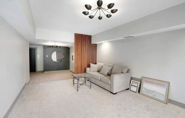 A living room with a couch, chair, and a picture frame on the floor.