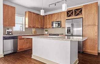 A kitchen with wooden cabinets and a white island.