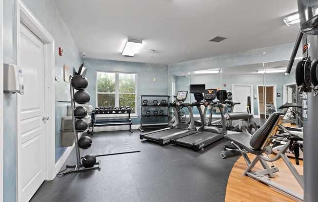 Ten05 West Trade Apartments' fitness center, which includes two treadmills, weighted medicine balls, a multifunctional machine, kettlebells and dumbbells.