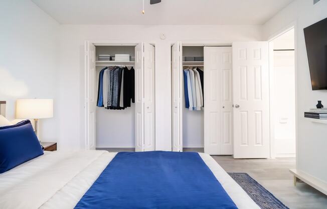 a bedroom with a bed and closet with a blue blanket