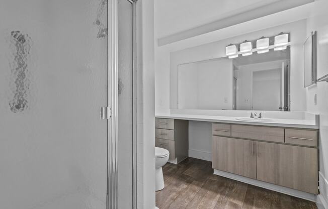 a bathroom with a toilet and a sink and a mirror at Edge At Farmington Hills - Farmington Hills, MI, Michigan