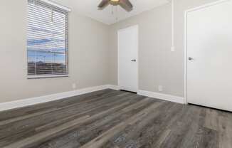 a bedroom with hardwood floors and a ceiling fan