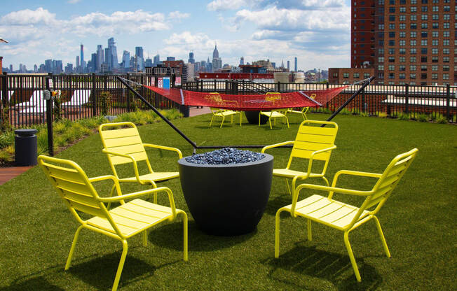 a group of yellow chairs sitting around a fire pit at The Enclave, Jersey City, New Jersey