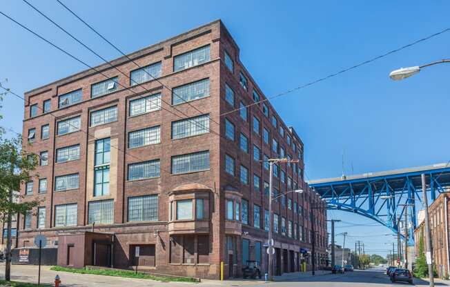 a large brick building with a bridge in the background