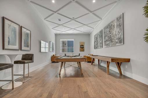 A room with a long table and chairs on the left and a long table and chairs on the right.