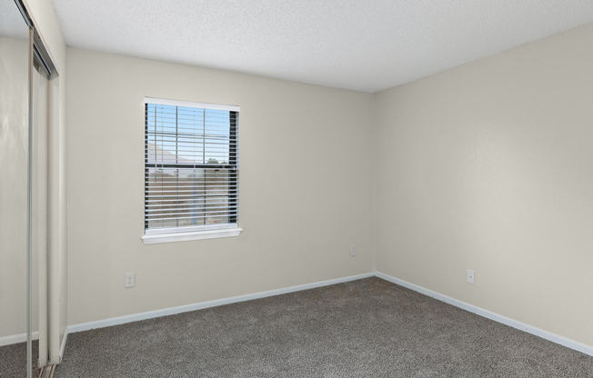 Gold carpeted bedroom interior at The Arbor Apartments in Blue Springs, Missouri