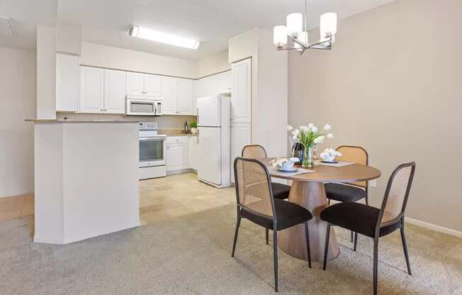 A kitchen with a dining table and chairs. at Towers at Costa Verde Apartments, San Diego, CA