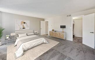 A bedroom with a large bed and a bench.