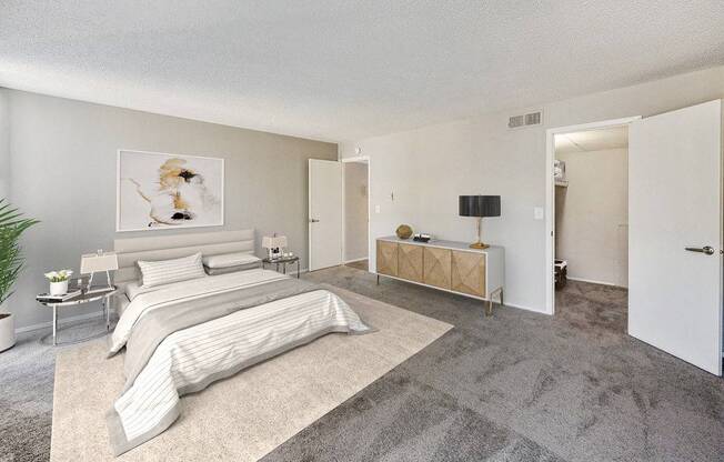 A bedroom with a large bed and a bench.