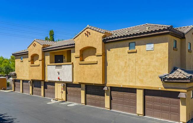 A row of tan stucco houses with garage doors.