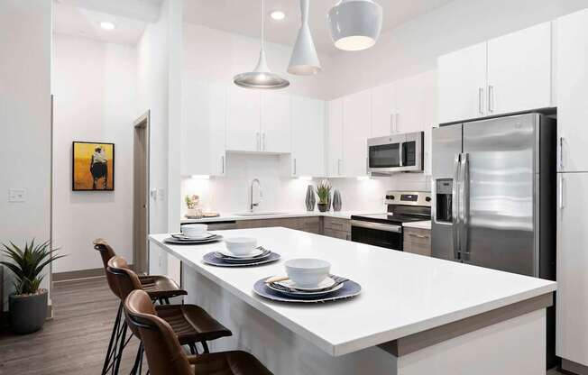 A modern kitchen with a white countertop and stainless steel appliances.